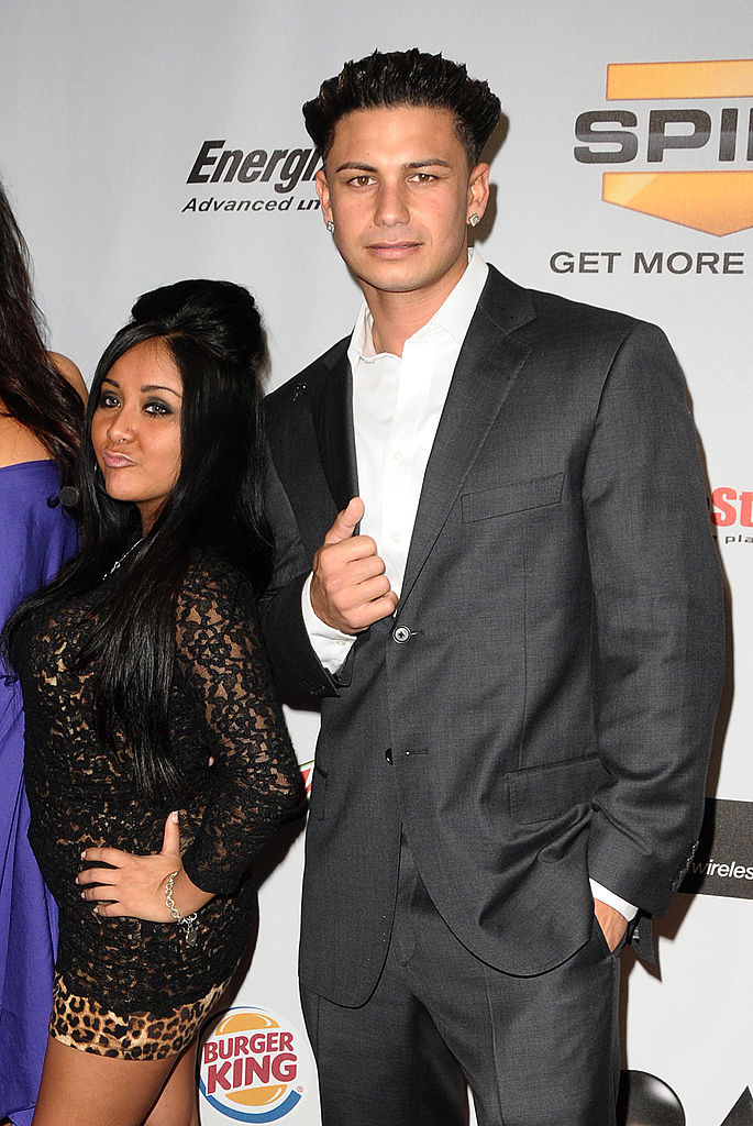 With spiked hair in a suit and standing next to Snooki