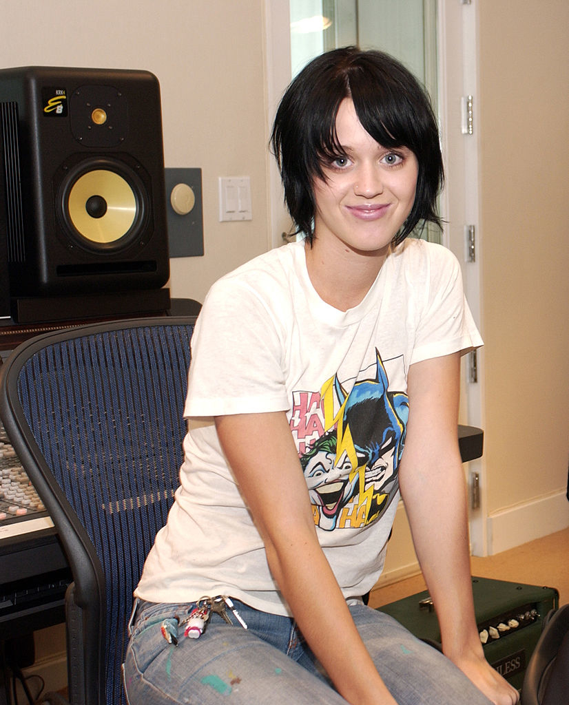 Seated, smiling, and wearing jeans and a T-shirt