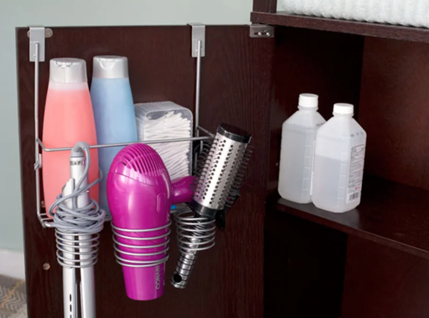 an open cabinet with a metal organizer holding hair accessories