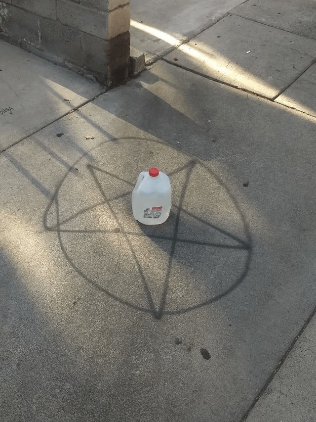 A pentagram with a jug of milk on it