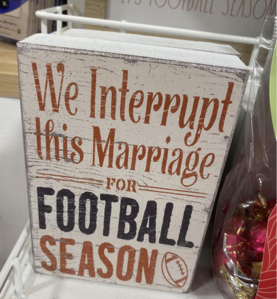 a sign that reads, &quot;We interrupt this marriage for football season&quot;