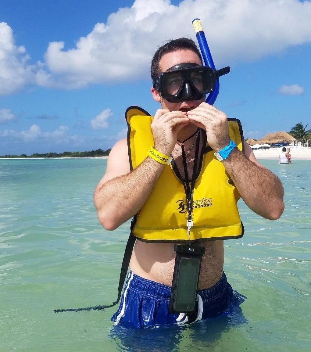a reviewer wearing the phone around their neck in the ocean while snorkeling