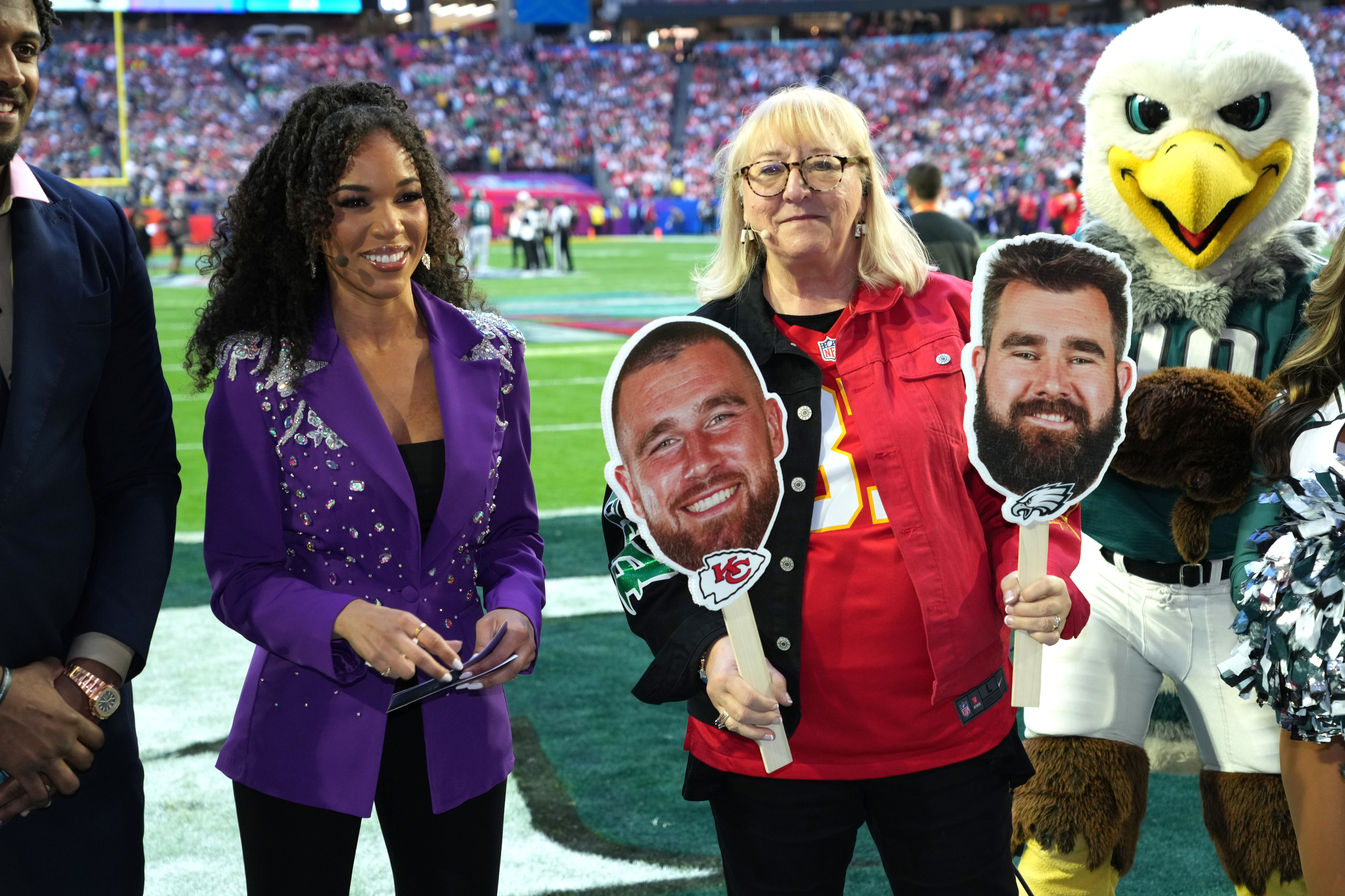 donna with reporters holding large photos of her kid&#x27;s faces