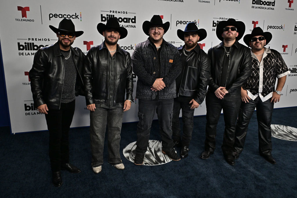 the group wearing leather jackets and dark pants with cowboy hats