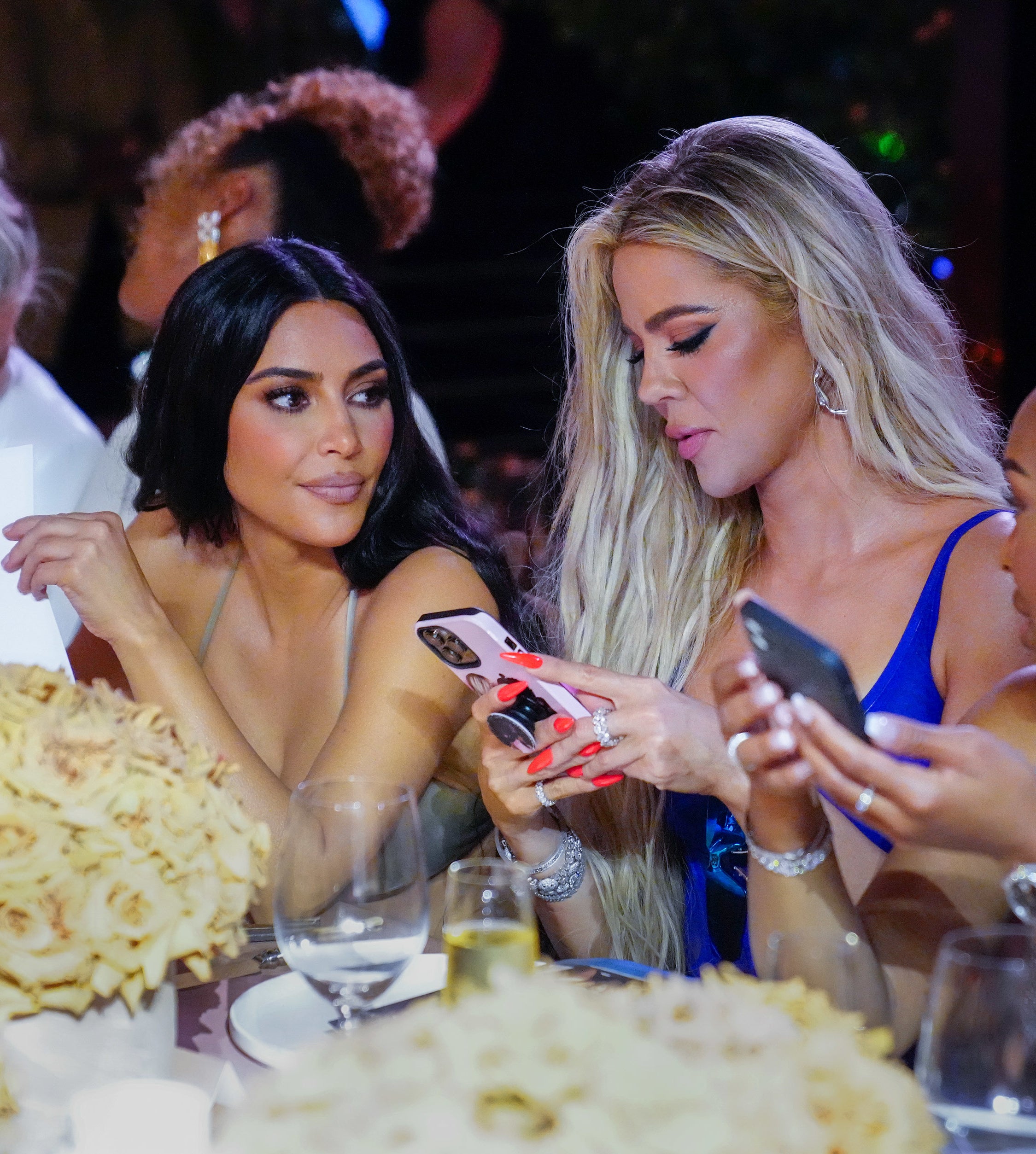 Kim and Khloé sitting at a table