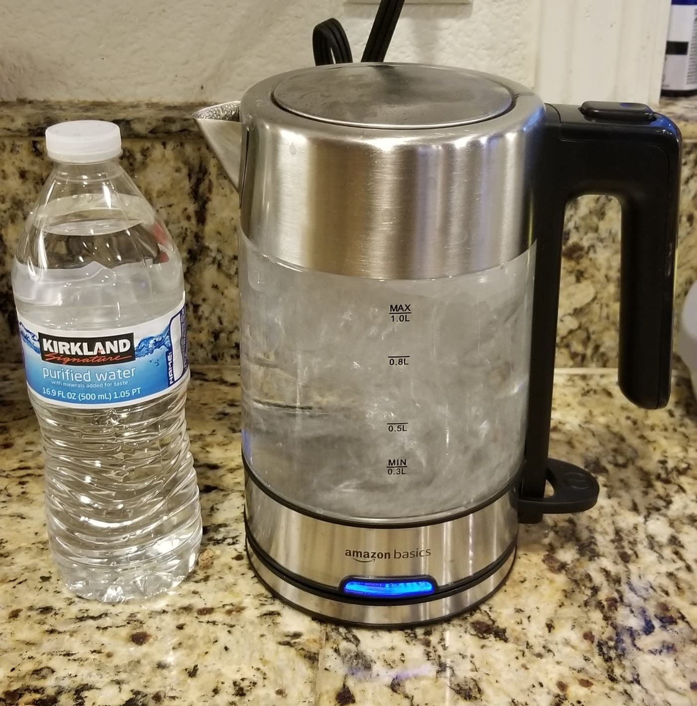 Reviewer image of the kettle on their counter with a water bottle next to it