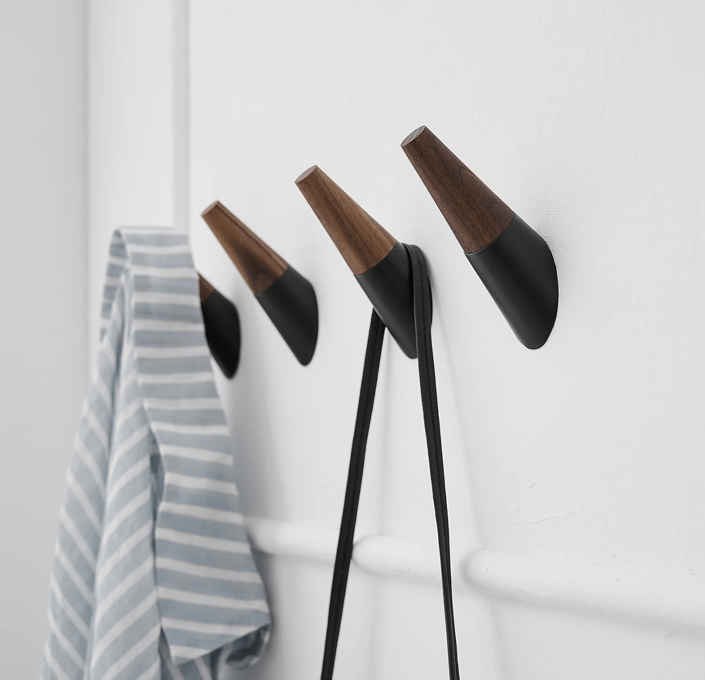 brown and black towel hooks mounted on white door