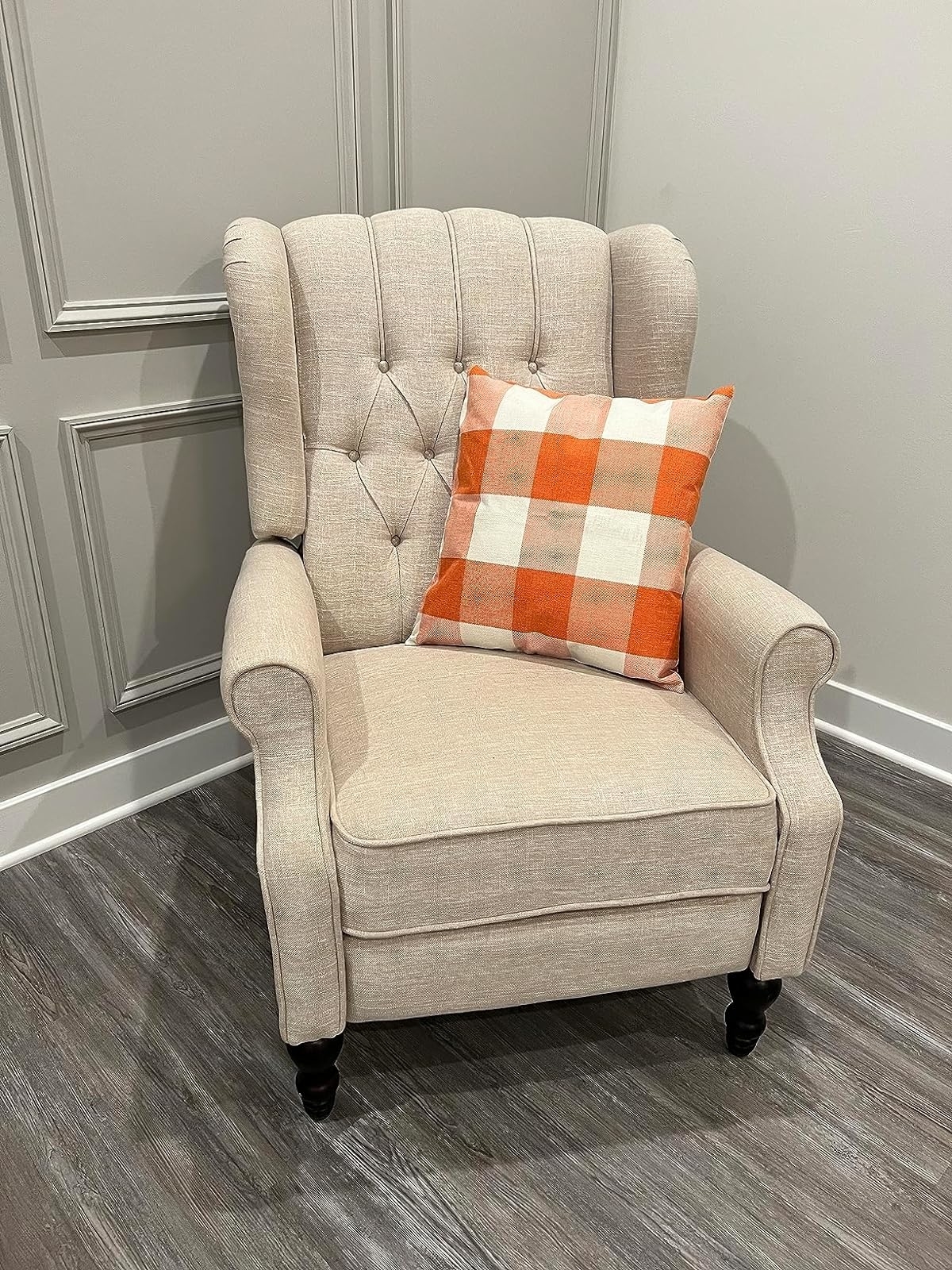 Reviewer image of the orange and cream plaid pillow on a beige armchair