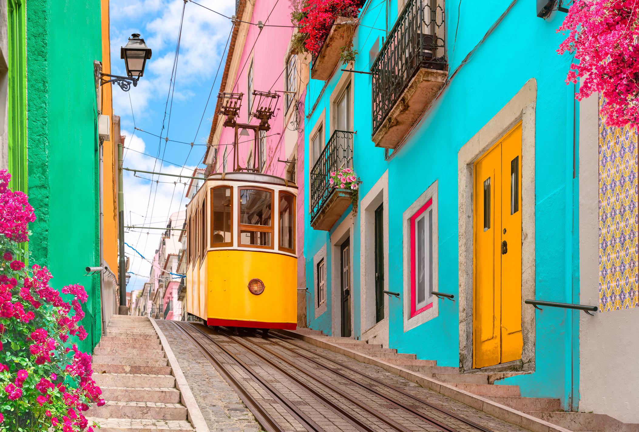 a cable car going down a hill in lisbon, portugal surrounded by colorful buildings