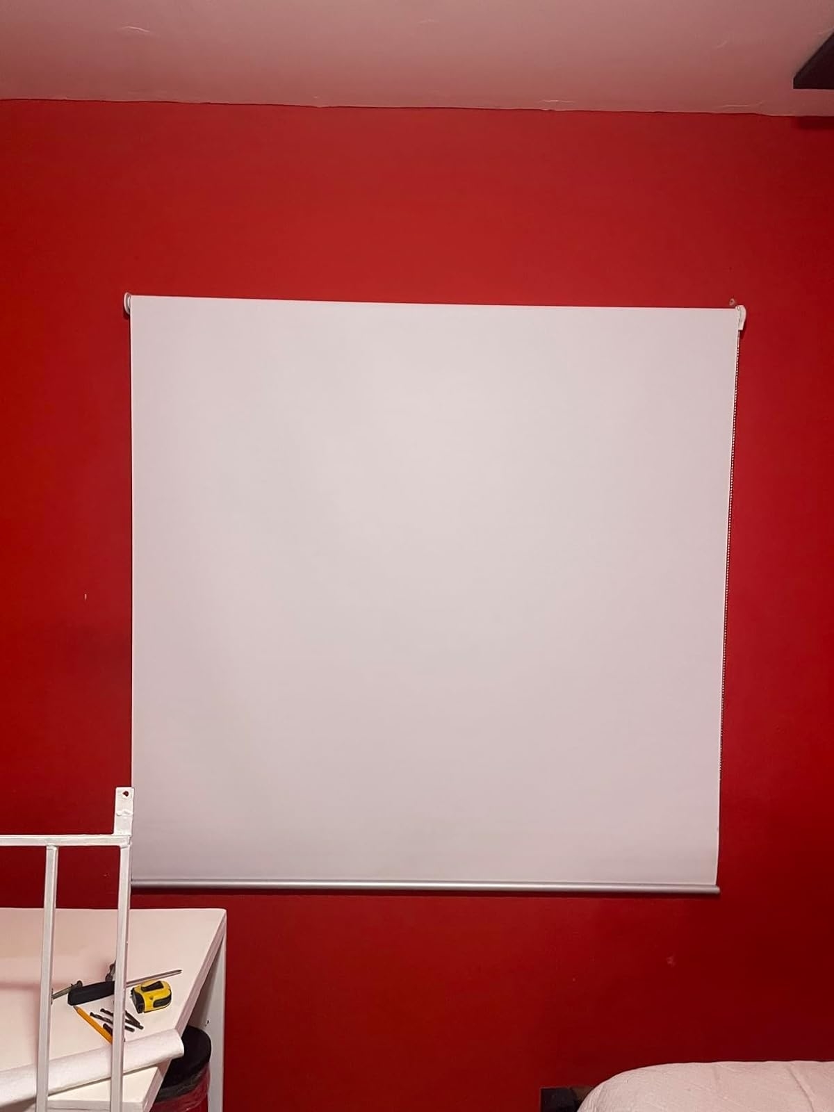 Reviewer image of the roller shade on a window in a room with red wall
