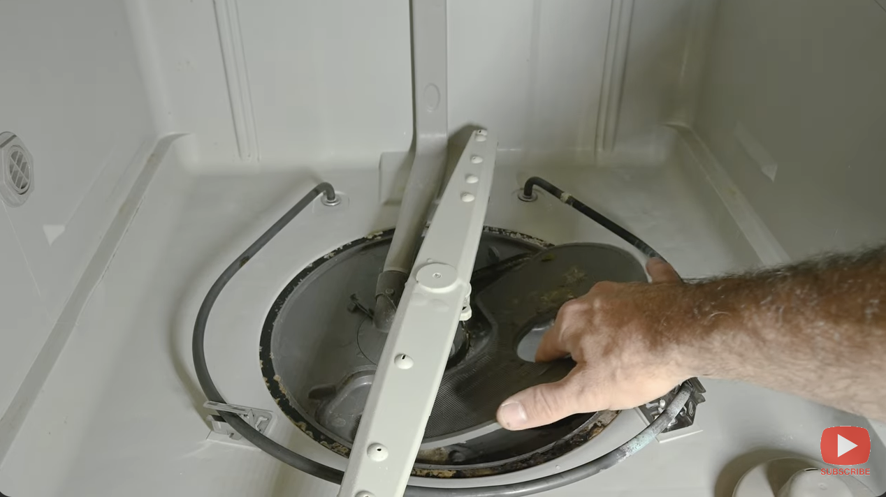 man removing a dishwasher filter