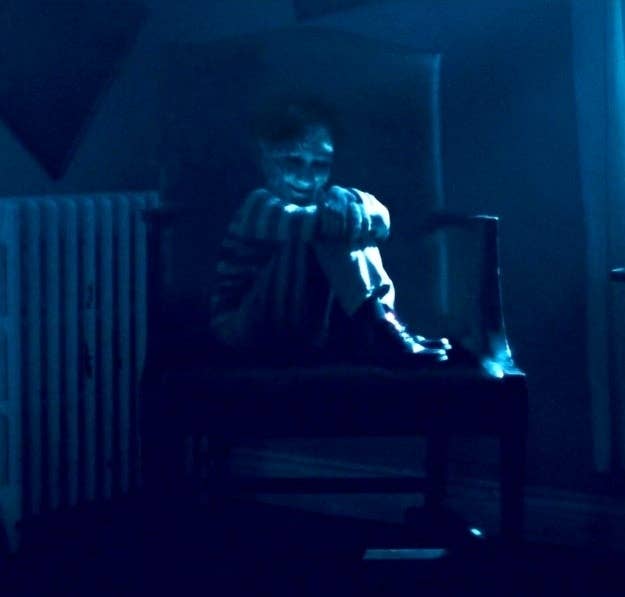 dear david child demon sitting in chair in dark