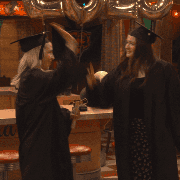 Two high school grads high five.