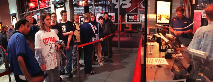 line of people waiting to buy tickets at the movie