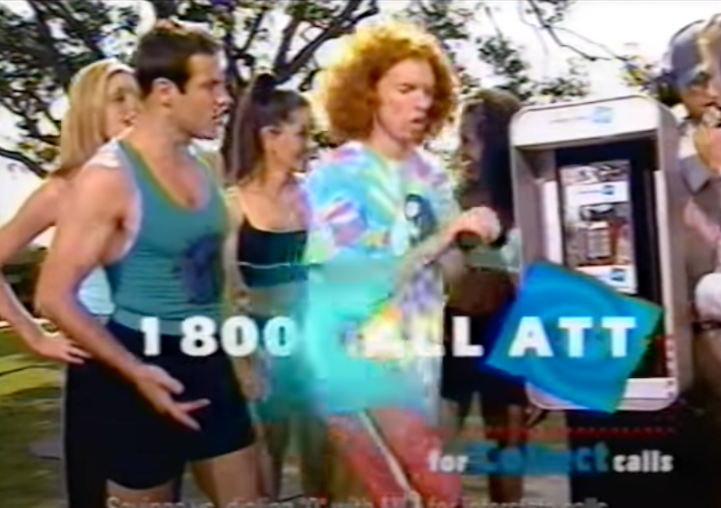 carrot top surrounded by people at the phone booth