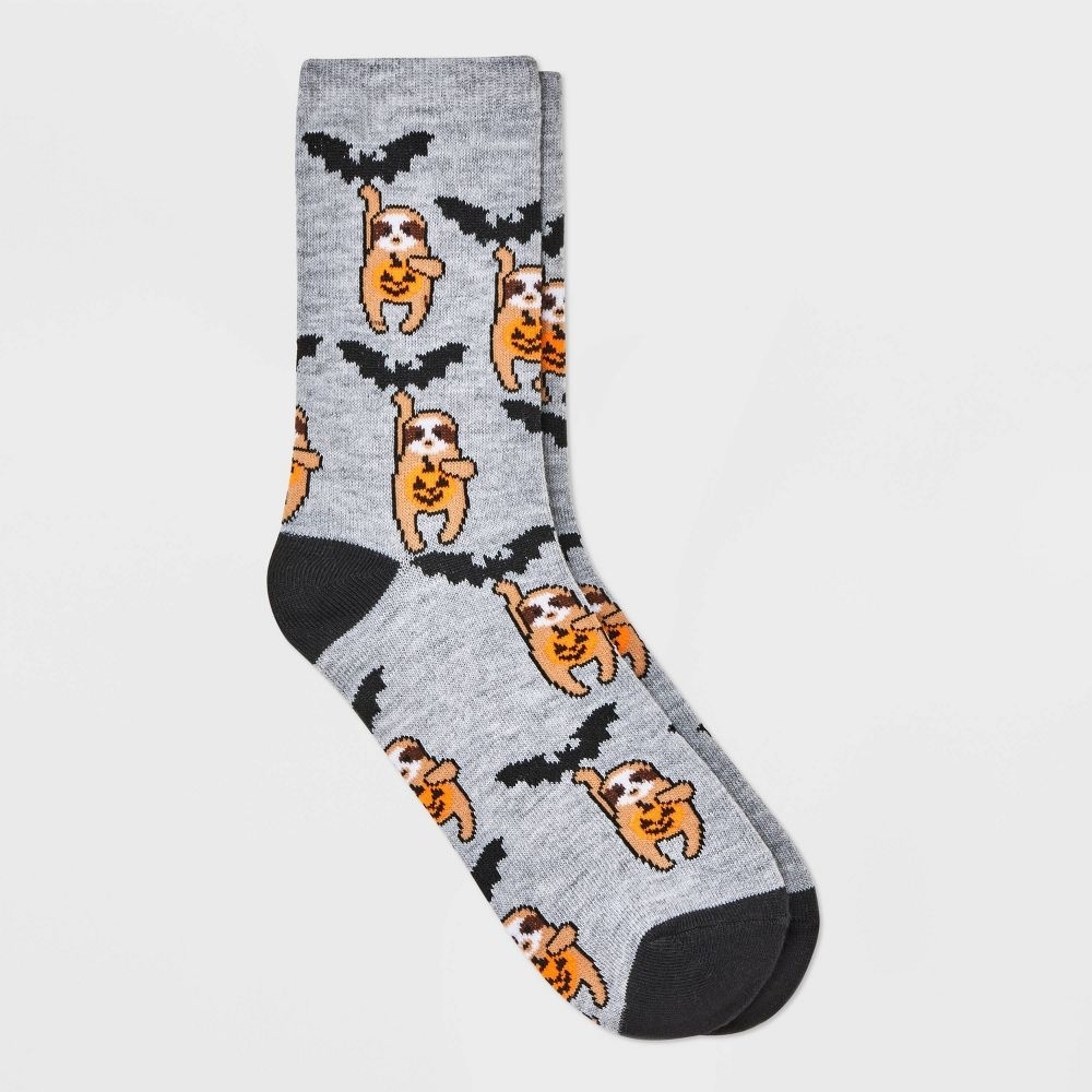the sloth socks with the sloth hanging on a bat and holding a pumpkin