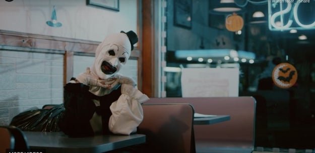 A scary-looking clown puppet sitting in a diner