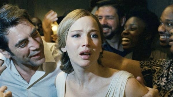 Jennifer Lawrence and Javier Bardem with a group of happy people behind them