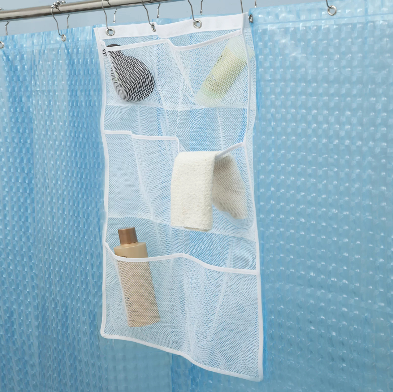 a white mesh shower caddy hanging from a shower curtainr od