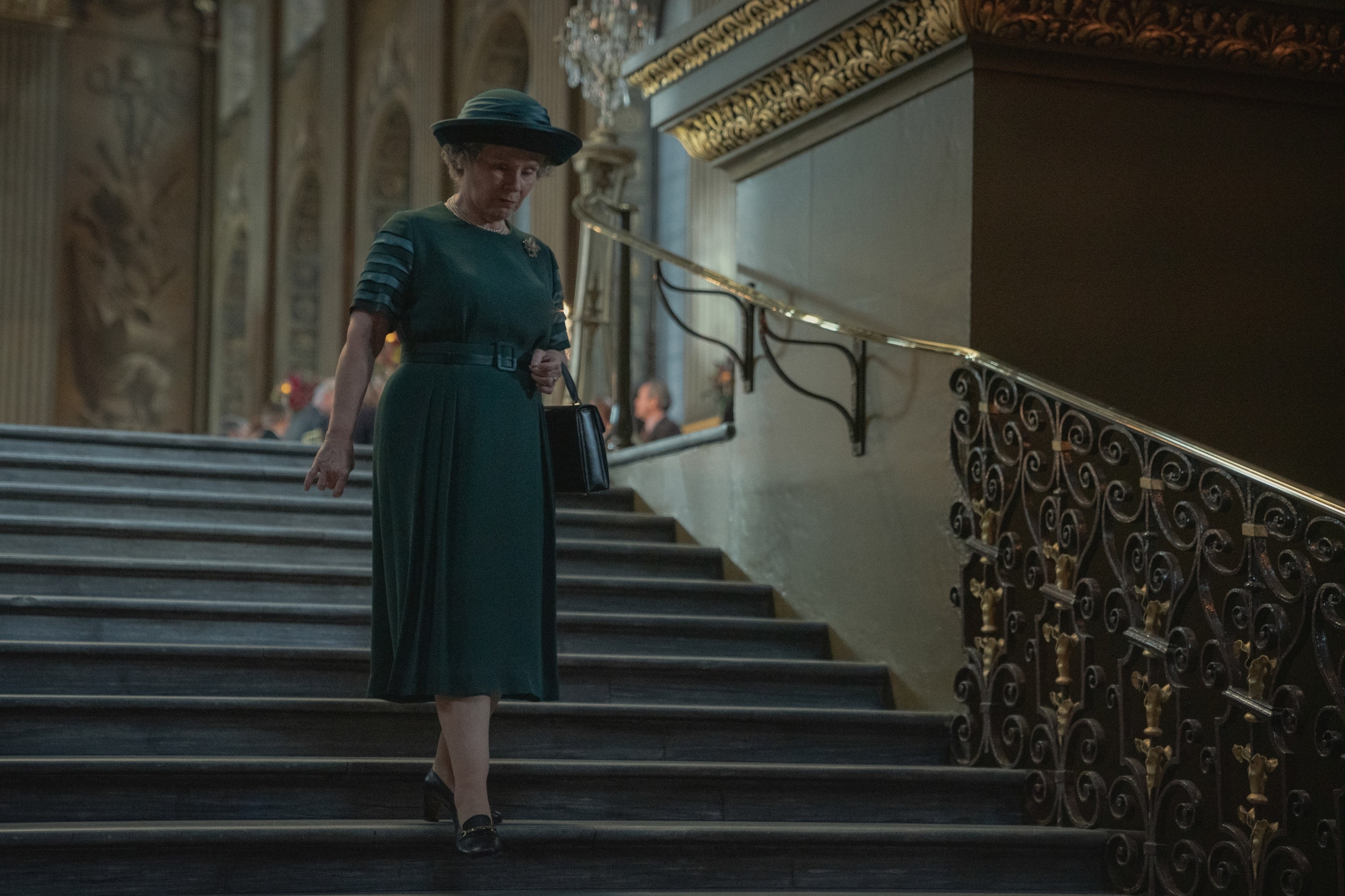 The Queen walking down a flight of stairs in the series