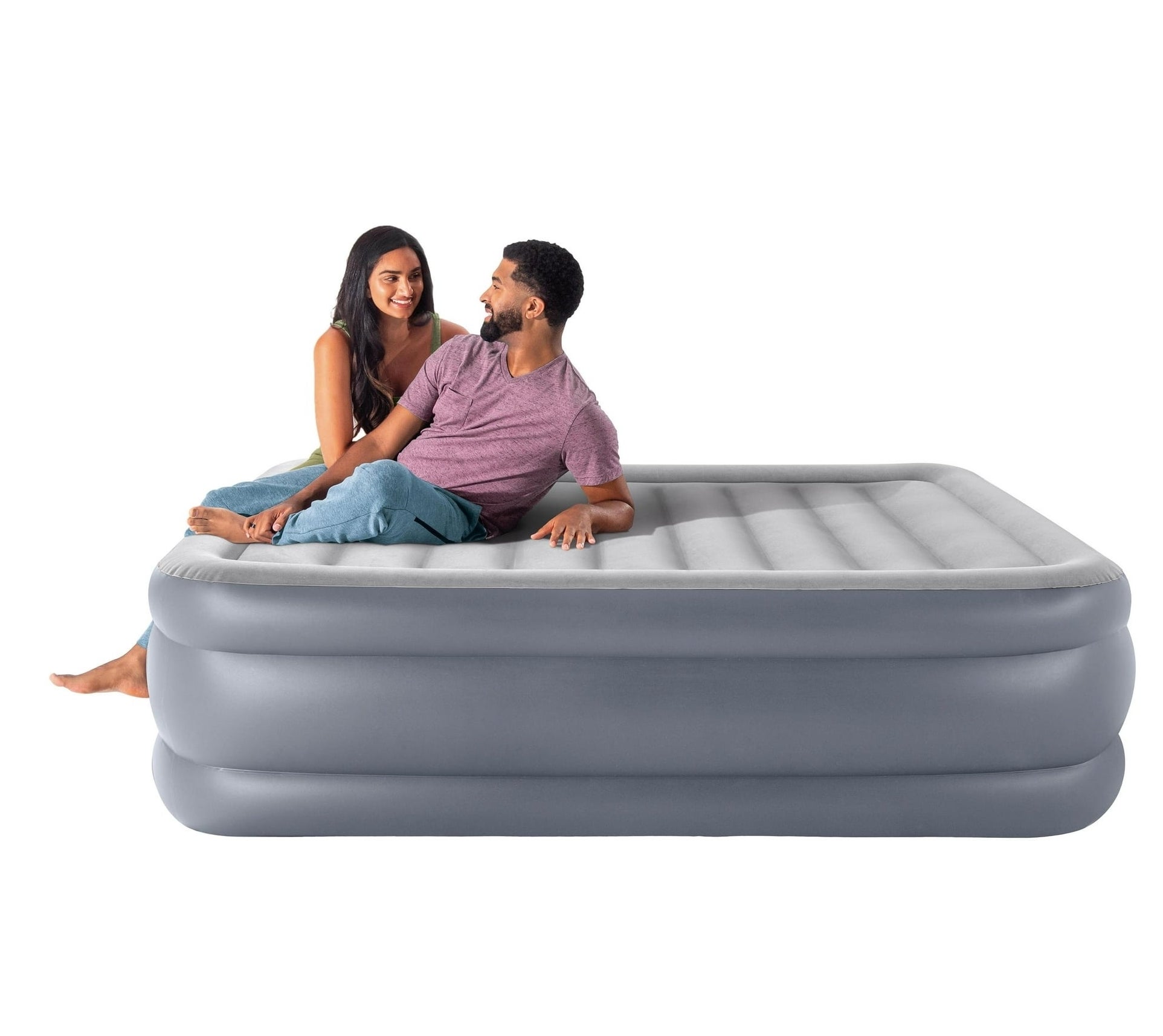 Two models sitting on the grey air mattress.
