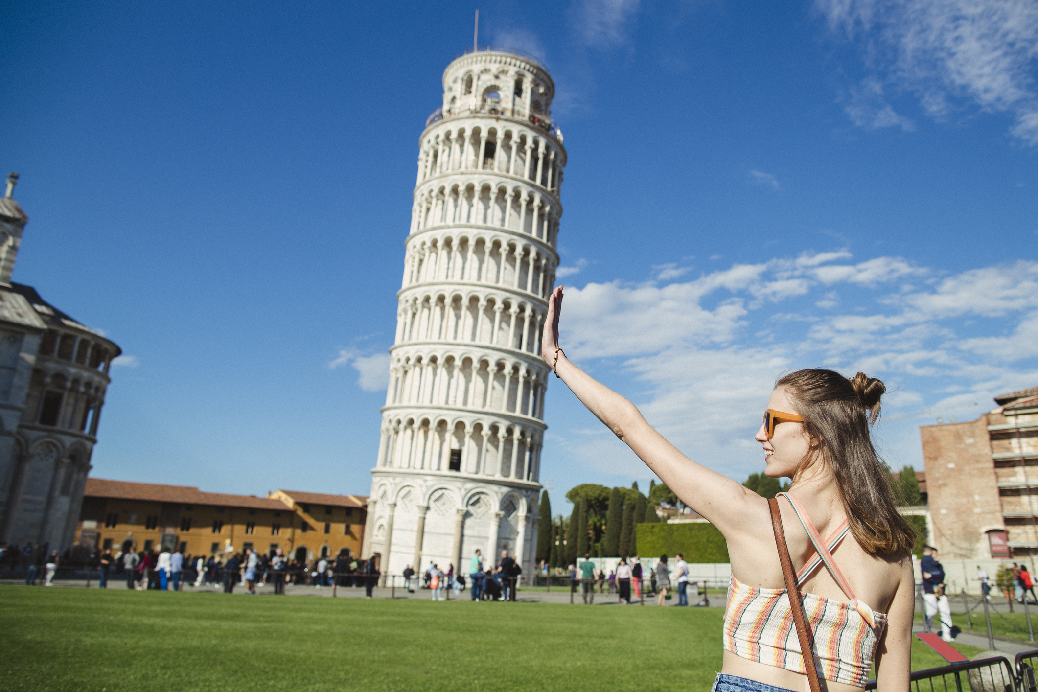 A tourist taking a photo of the Leaning Tower of Pisa