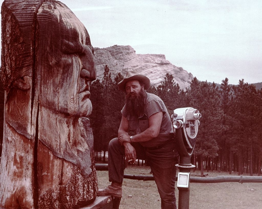 A man next to sculpture