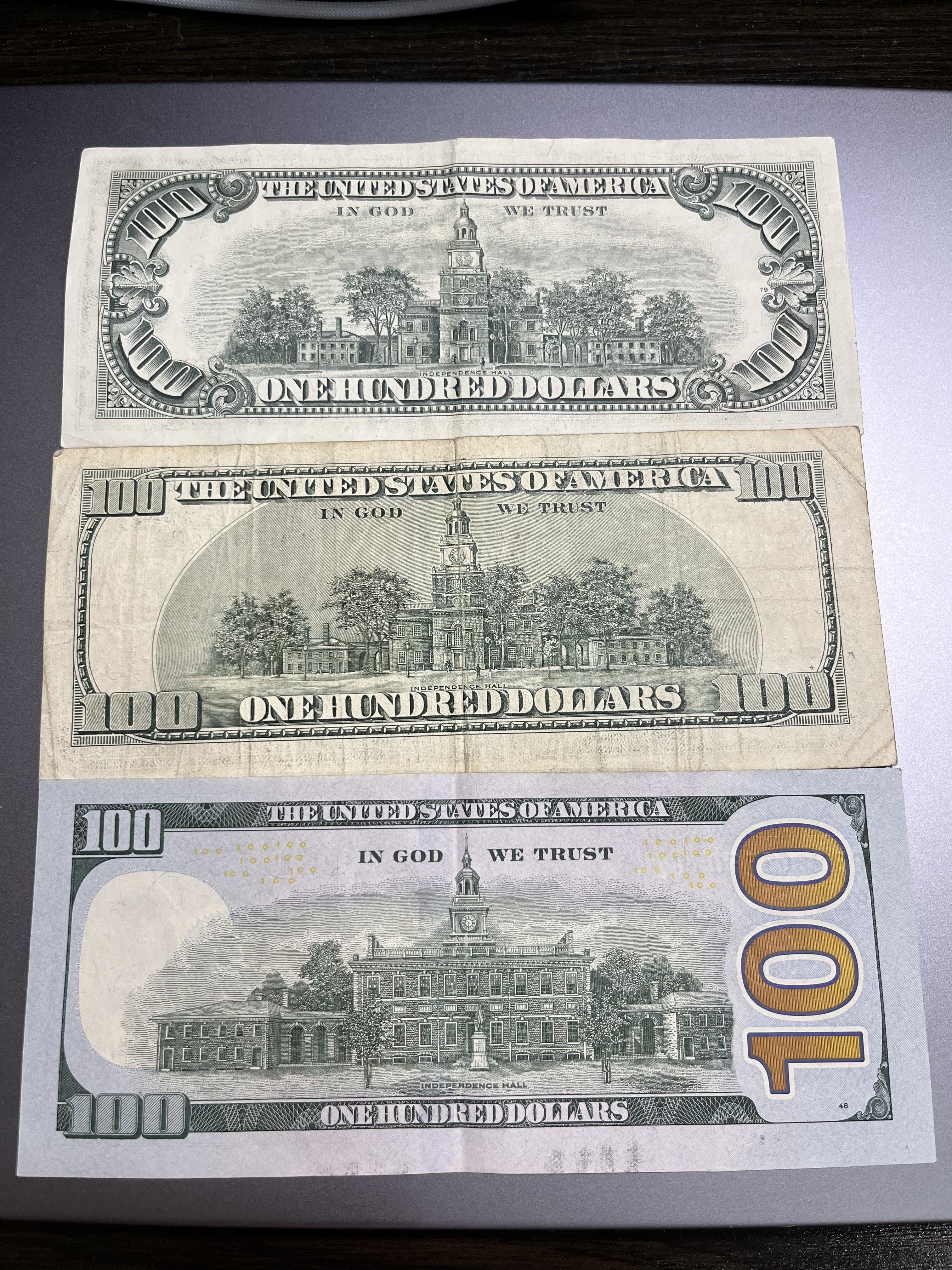 Back view of all three: 1977 has an ornate font for &quot;100,&quot; 2003 has a simpler font, 2017 has a new illustration of Independence Hall and a redesigned, large vertical &quot;100&quot; in a different font