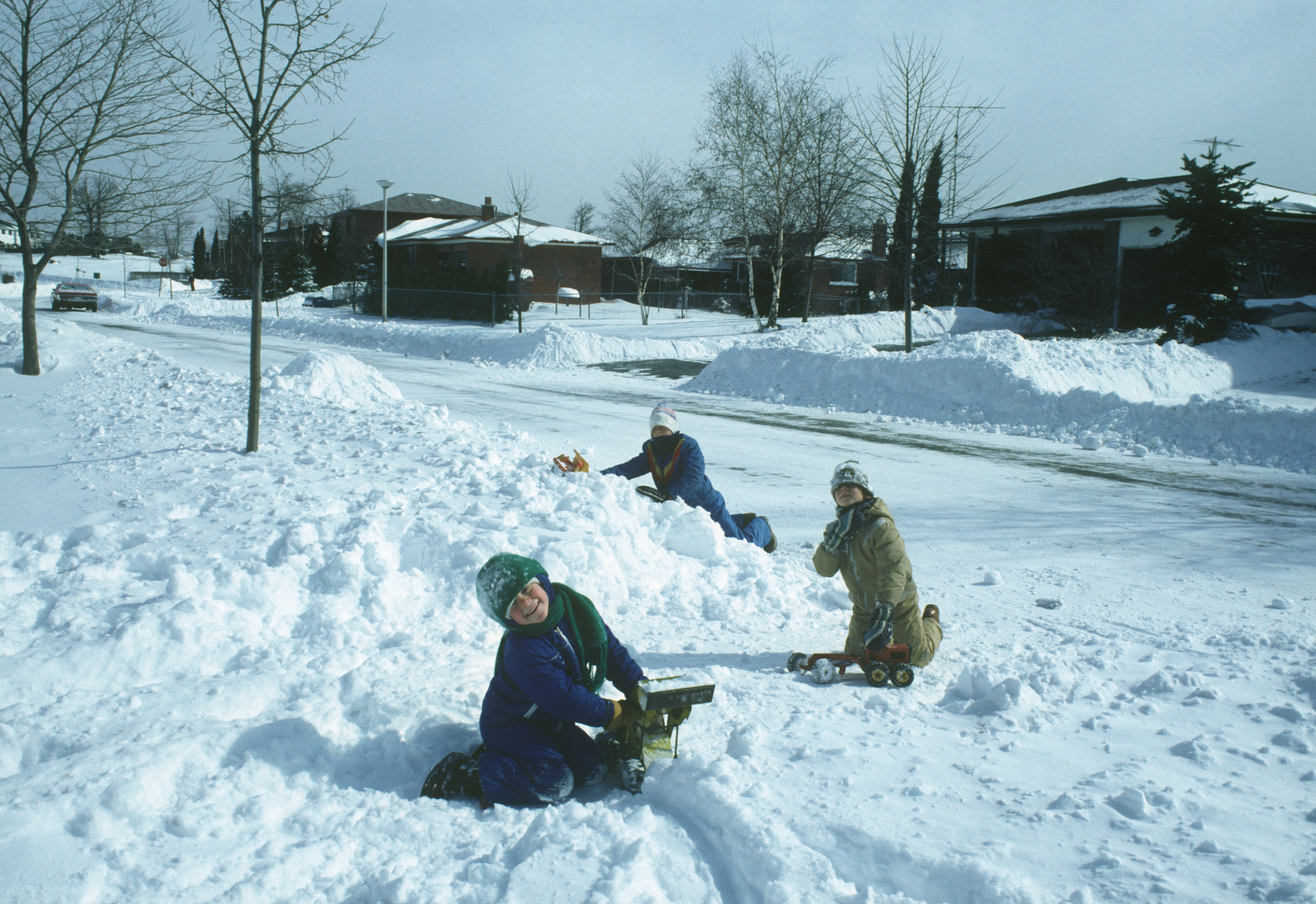 Three kids are enjoying a day in the snow