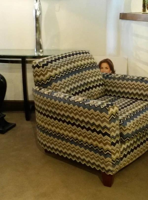 a poster of a person peeking out from behind a chair