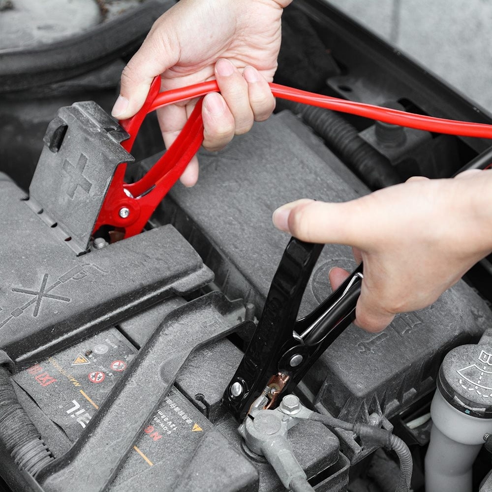 Jumper cables hooked up to a car