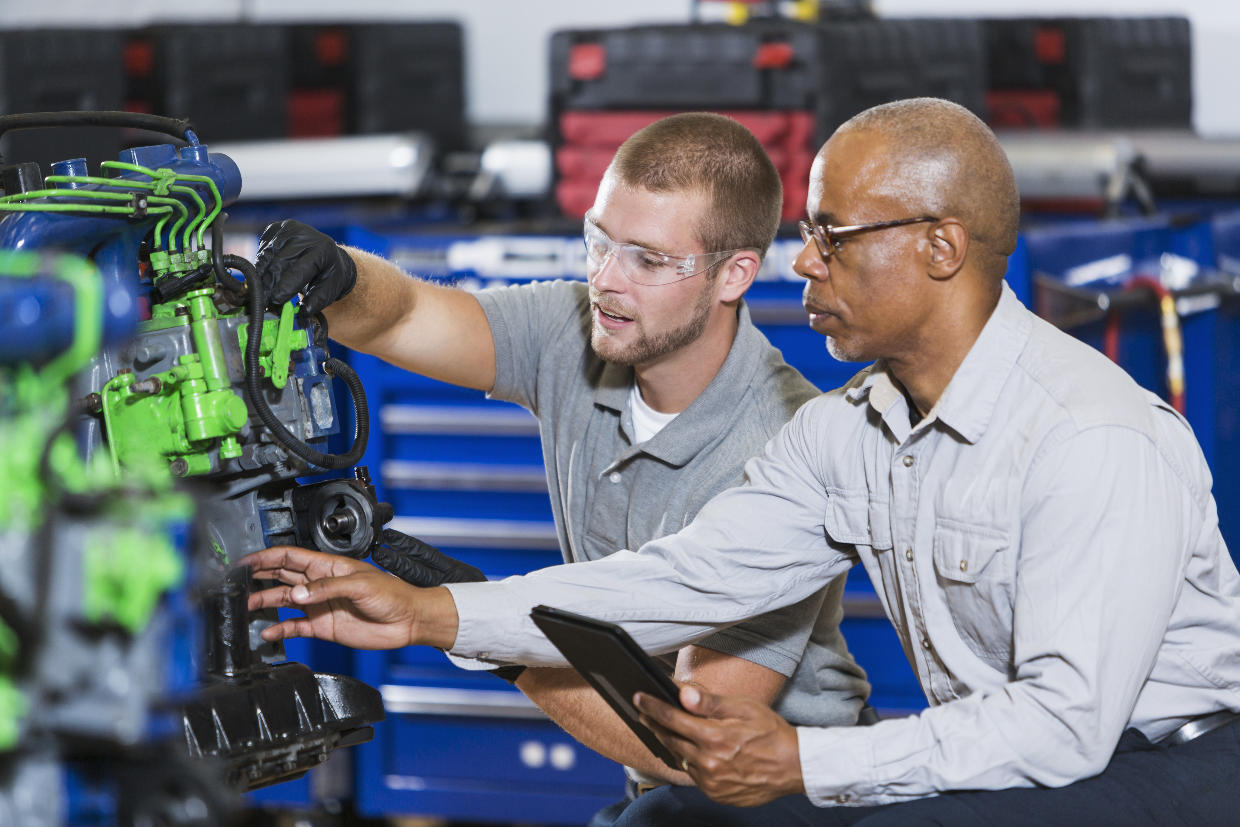 Instructor and student working on an engine in an automotive trade school class
