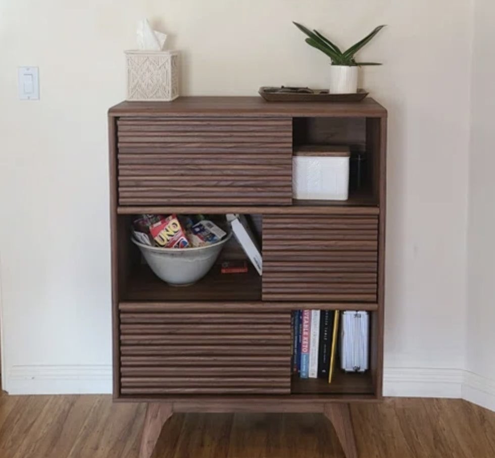 a wood accent table with books and games inside it