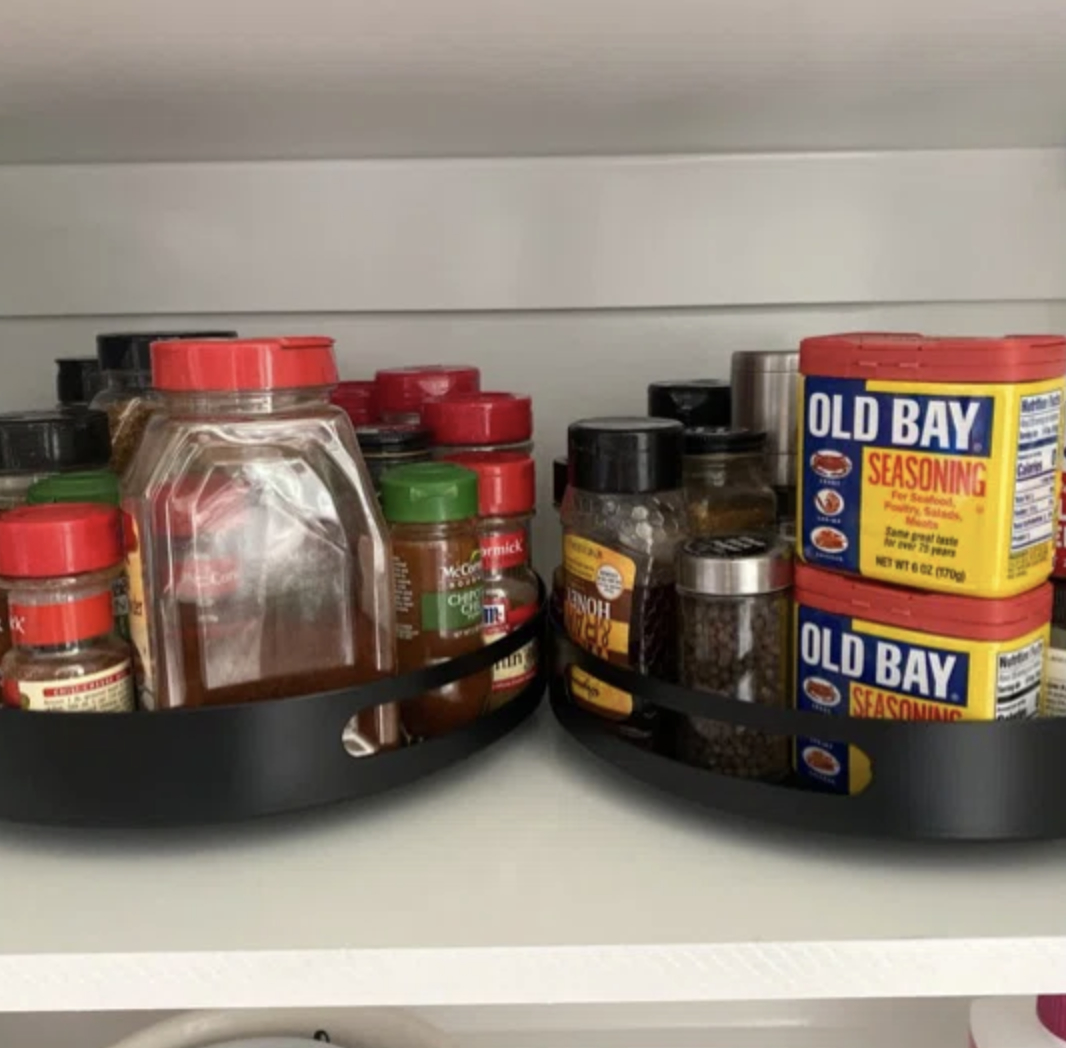 two rotating kitchen racks with condiments in a cabinet