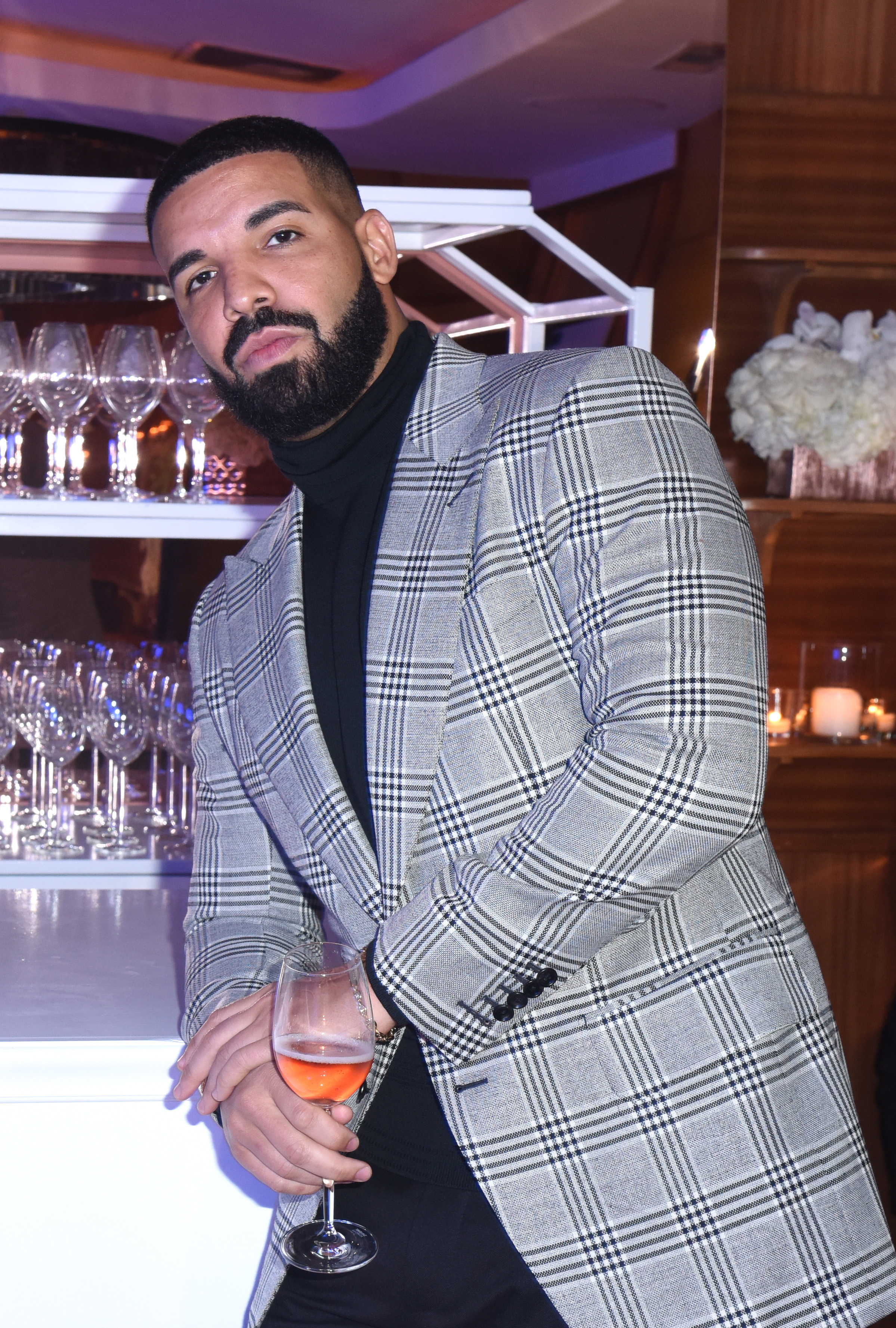 Drake at an event holding a glass of wine