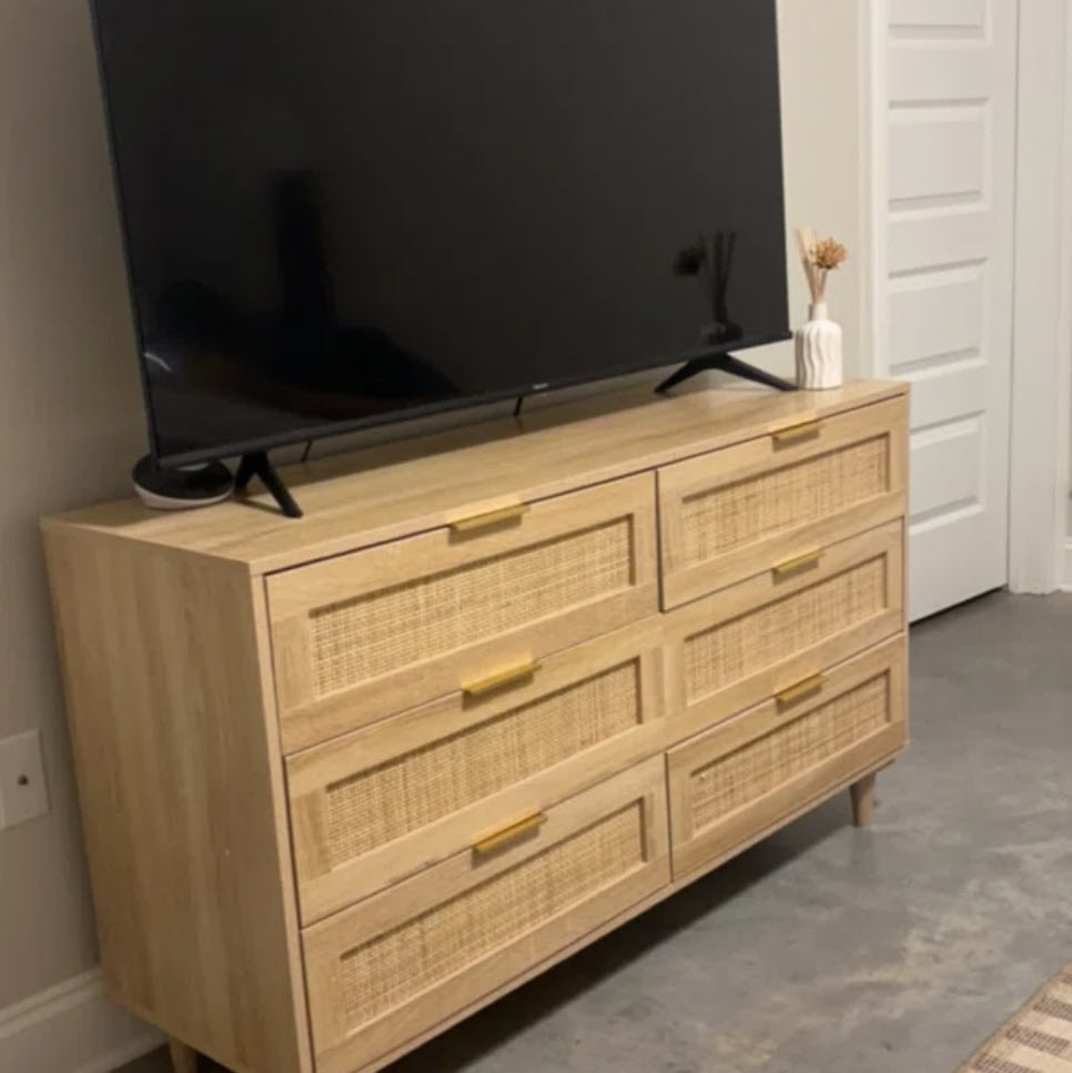 large bamboo dresser with six drawers with TV on top