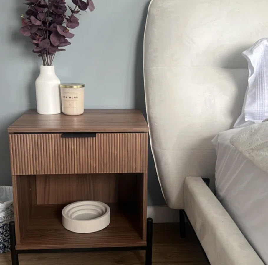 dark natural wood nightstand with ribbed drawer next to bed