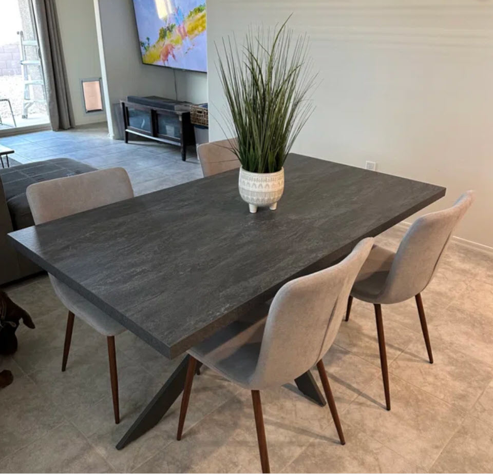 classic grey dining table with four light grey dining chairs with a faux plant centerpiece