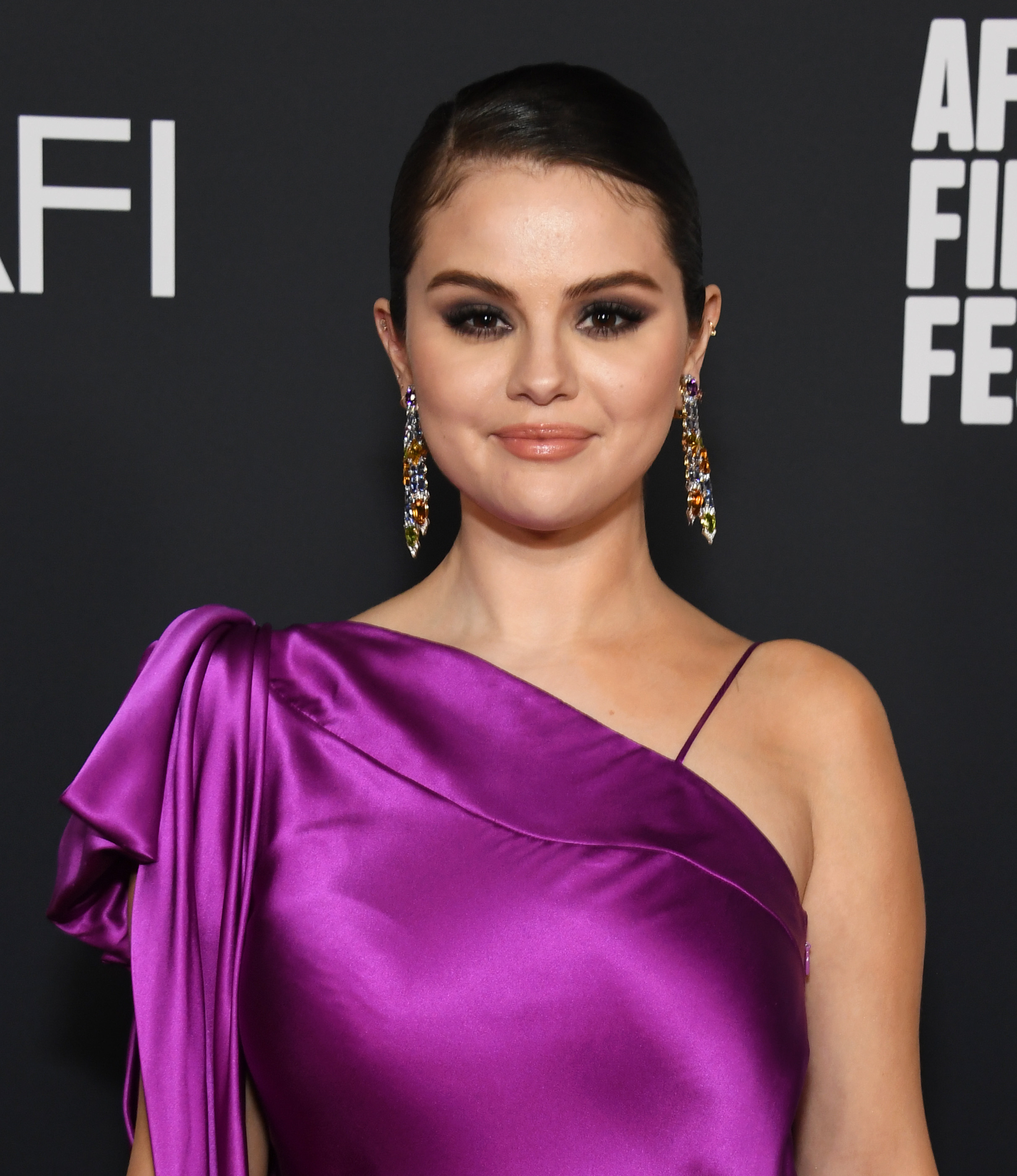 Closeup of Selena Gomez in a one-shouldered silk-like outfit on the red carpet