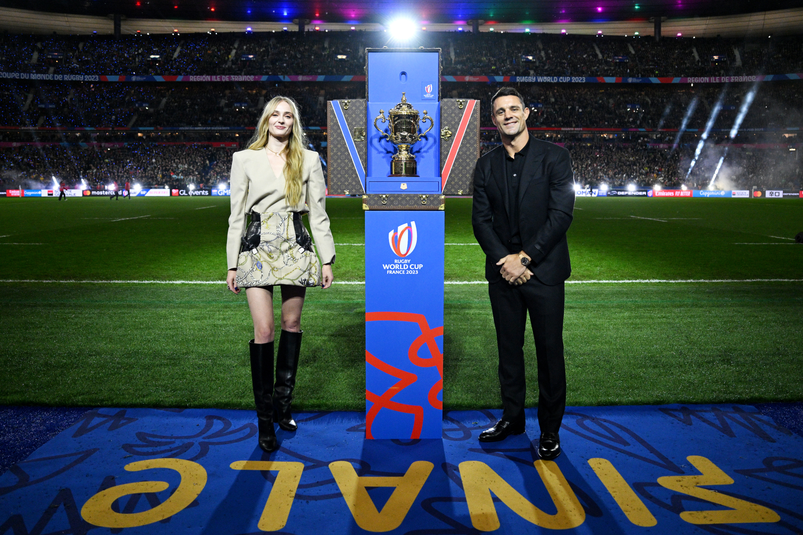 Sophie Turner on the pitch standing next to the trophy
