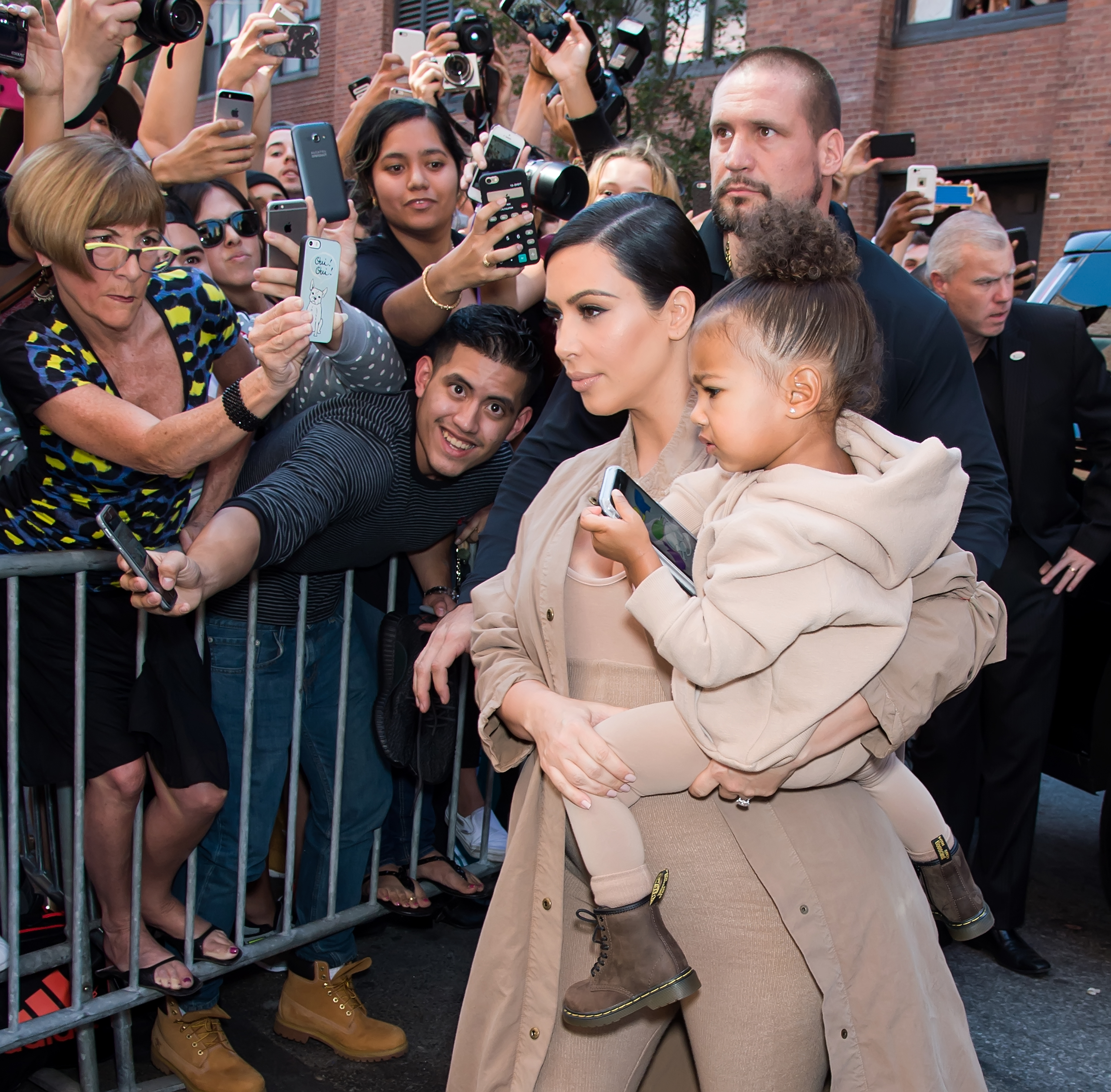 Kim and North walking by a crowd of people clamoring to take their picture