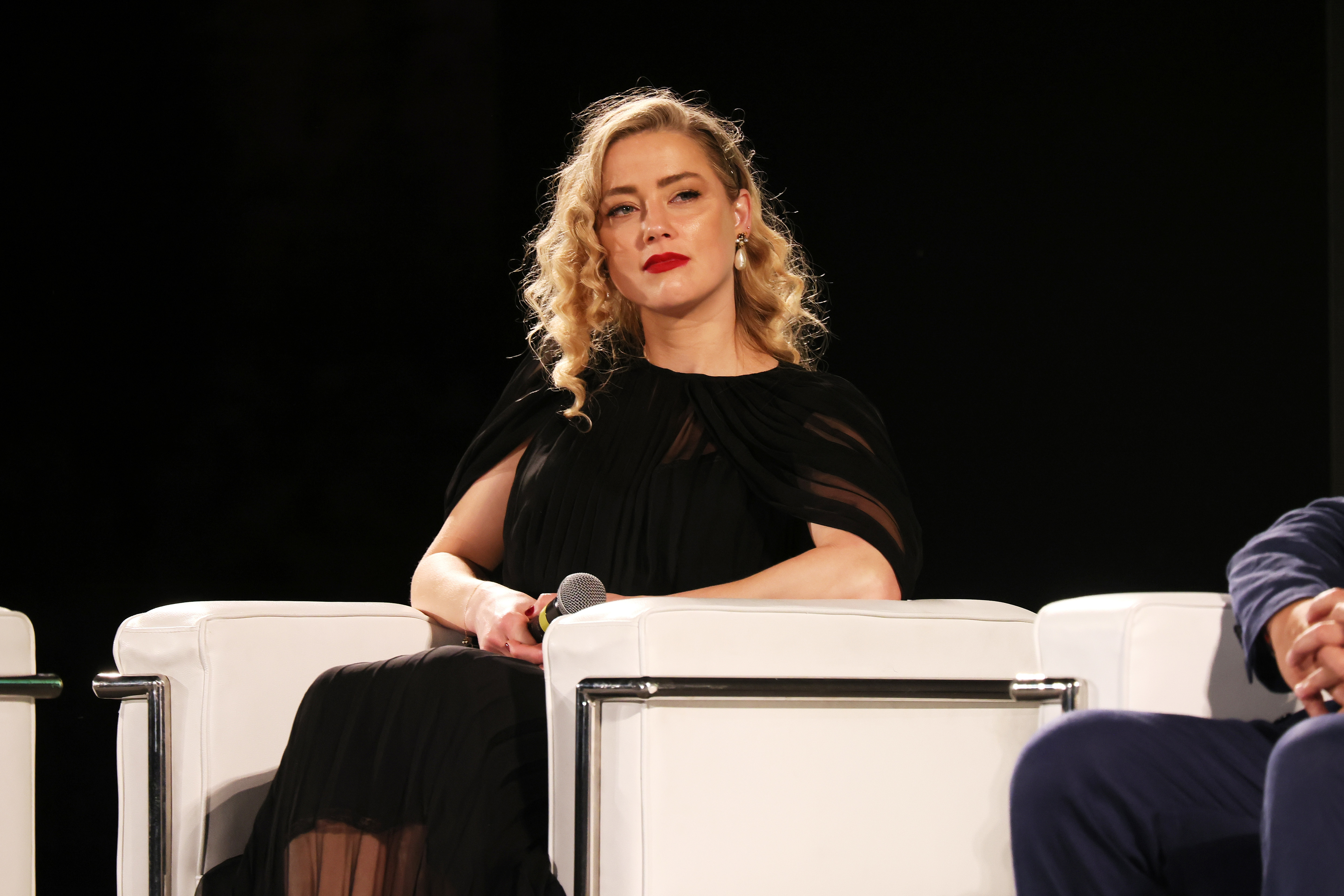 Amber Heard sitting on a panel