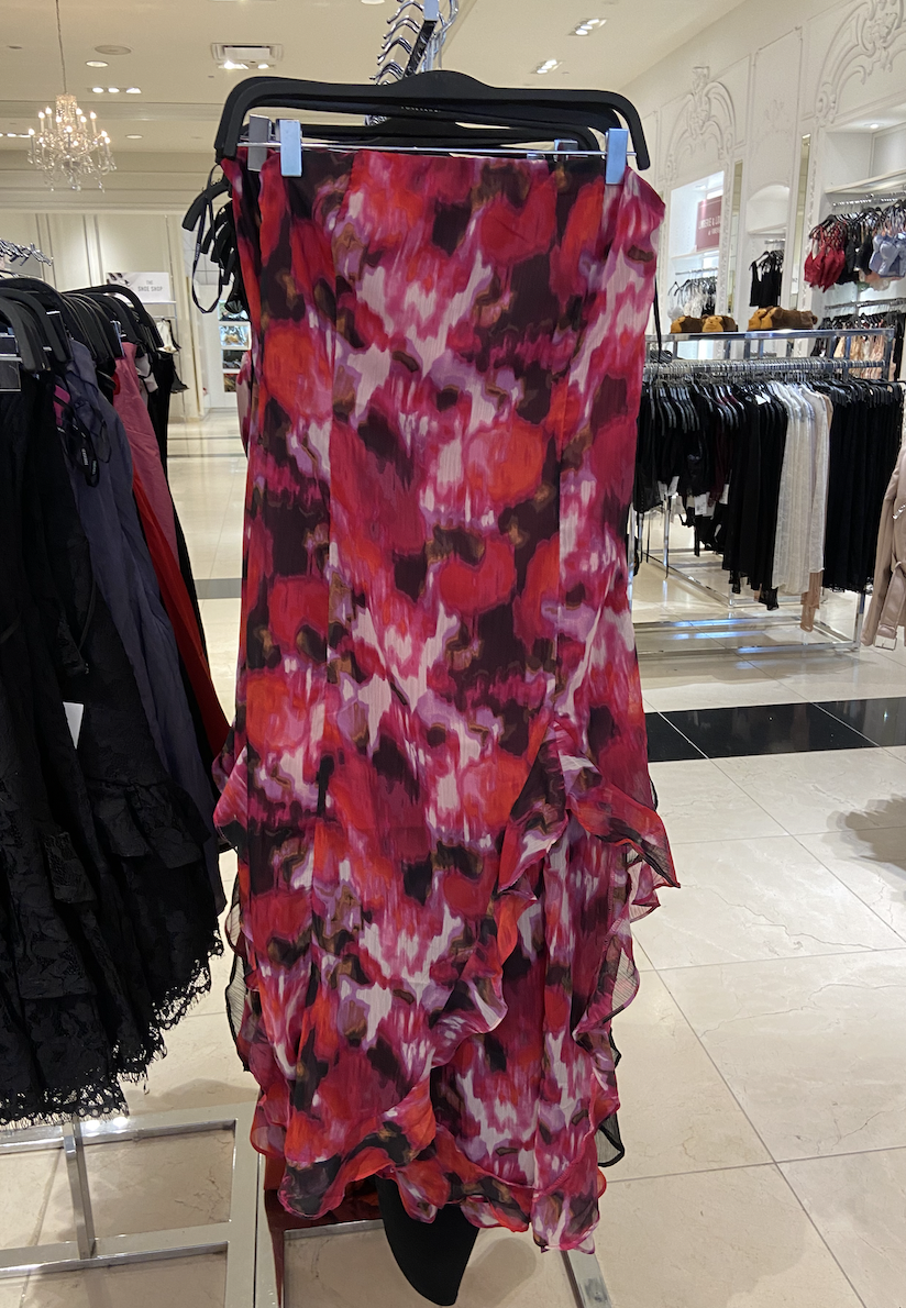 A sheer, frilly flower print dress with ruffles on the bottom