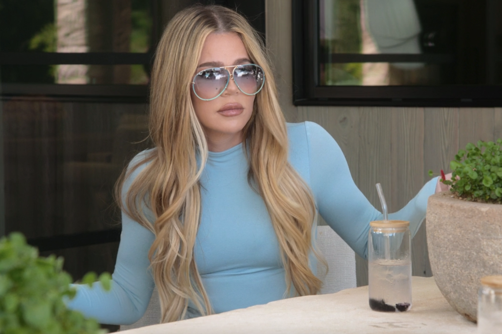 Close-up of Khloé at the table gesturing
