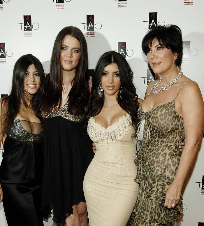 Khloé, Kourtney, and Kim Kardashian with Kris smiling at a media event