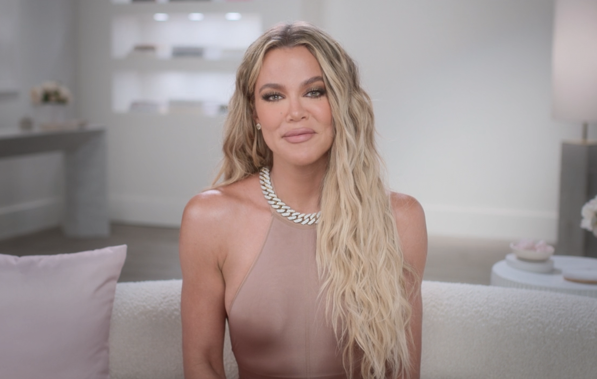 Close-up of Khloé sitting on a couch