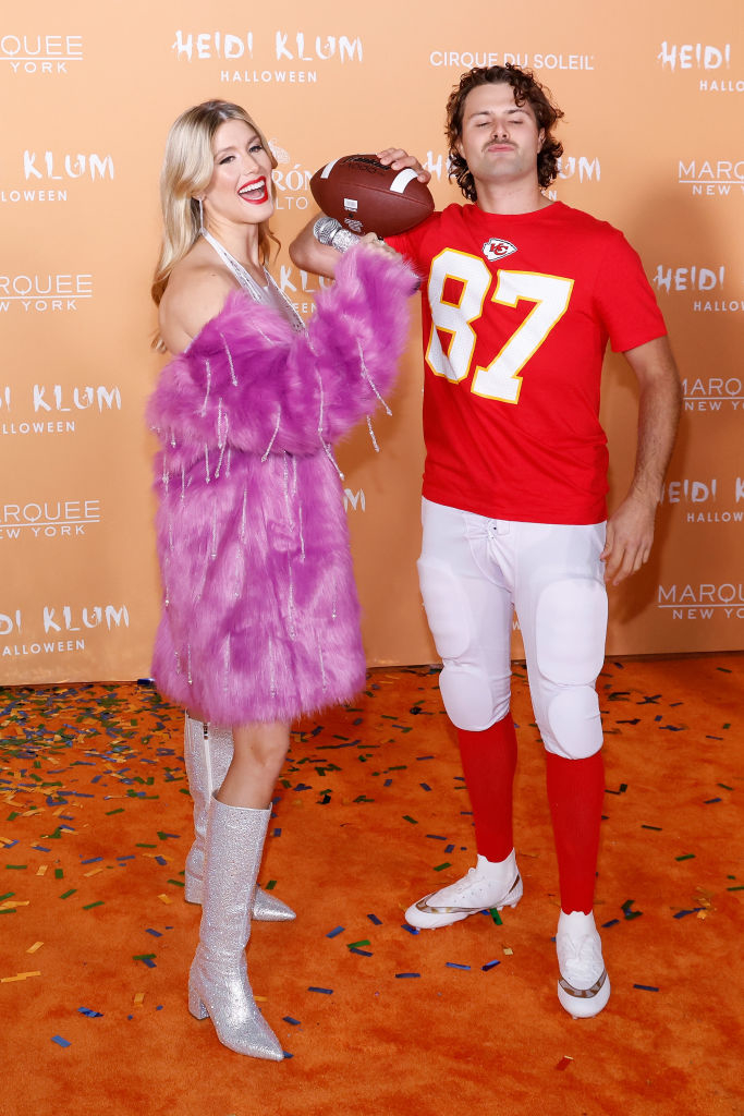 she's dressed in the singer's stage outfit and he's in the football uniform