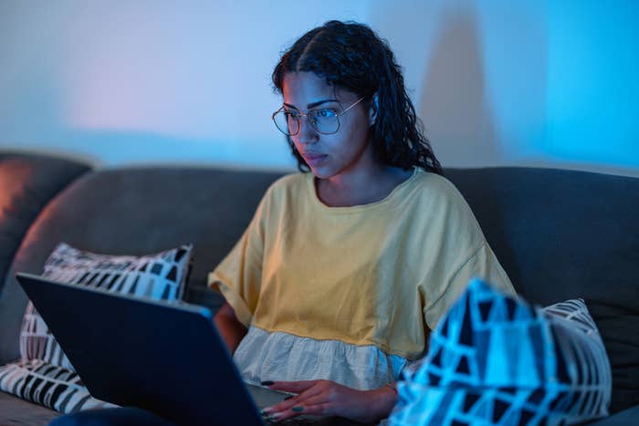 A woman on her laptop while sitting on the couch
