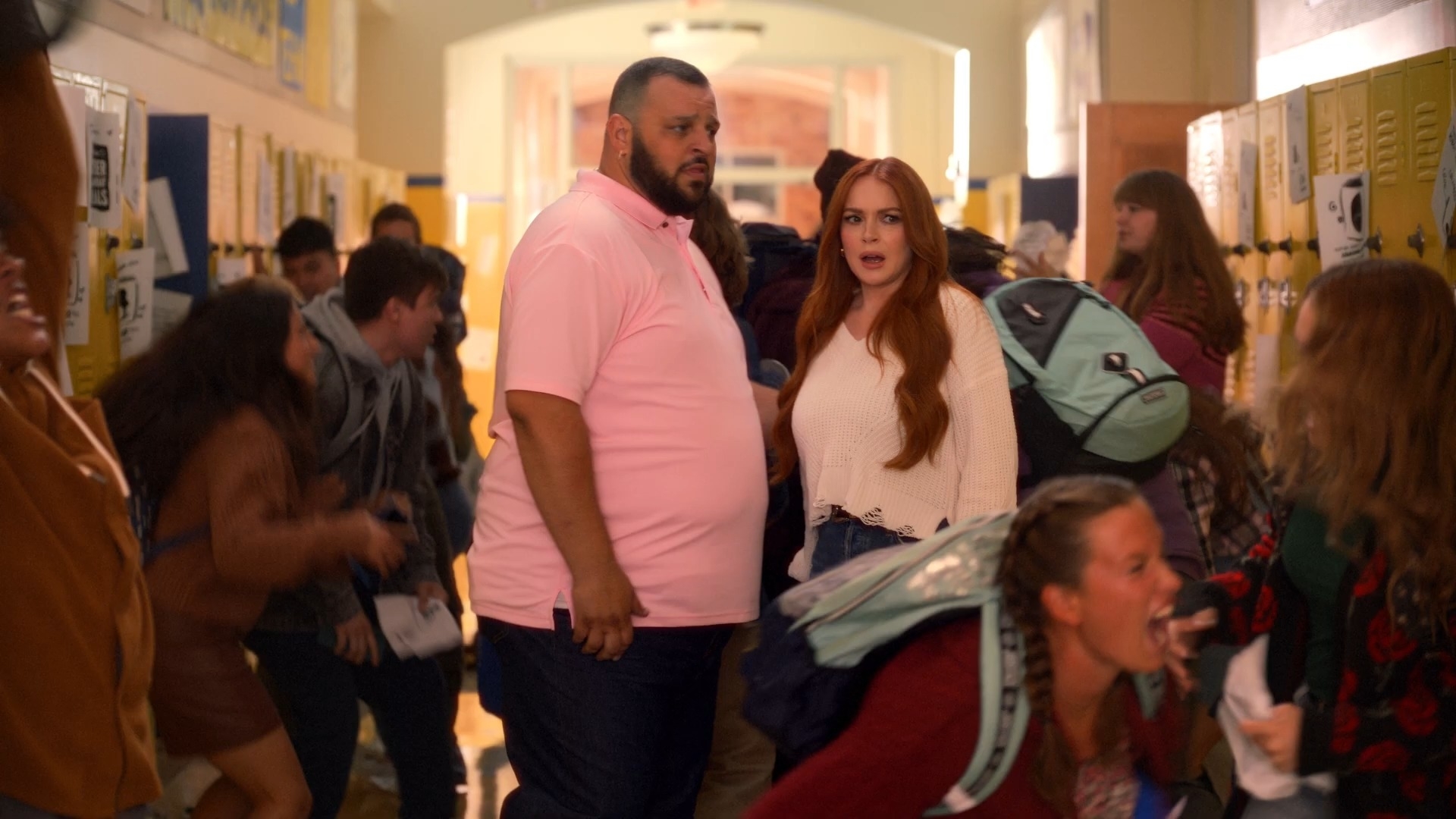 cady and damien looking scared in the middle of the hallway while students go wild