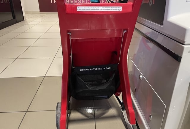bag at the bottom of a shopping cart says do not put child in bag
